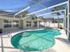 Inviting pool inside screened enclosure features a tanning ledge, ample deck space, and a backyard view at 8603 Primrose Dr, Kissimmee, FL 34747