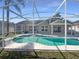 Screened-in pool with a blue-tile trim and a spacious patio offers a great outdoor entertainment space at 8603 Primrose Dr, Kissimmee, FL 34747