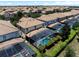 Scenic aerial view features a neighborhood of tile-roofed homes with screened-in pools and lush, green landscaping at 9023 Shadow Mountain St, Davenport, FL 33896