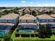 Expansive aerial view showcases tile roofs and screened pools in a well-maintained community, highlighting the neighborhood at 9023 Shadow Mountain St, Davenport, FL 33896