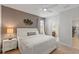 Neutral bedroom with a queen bed, side tables with lamps, and an ensuite bathroom at 9023 Shadow Mountain St, Davenport, FL 33896