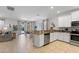 Open kitchen with stainless steel appliances, granite countertops, breakfast bar, and access to the living area at 9023 Shadow Mountain St, Davenport, FL 33896