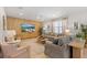 Comfortable living room with tile floors, ceiling fan, modern decor and a large wall mounted television at 9023 Shadow Mountain St, Davenport, FL 33896