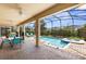 Screened-in pool and patio area with a table, chairs, and lounge seating for outdoor relaxation at 9023 Shadow Mountain St, Davenport, FL 33896