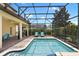Screened-in pool and patio area with outdoor seating and lush landscaping at 9023 Shadow Mountain St, Davenport, FL 33896