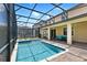 Gorgeous screened-in pool and spa with brick paver patio offer a refreshing oasis to relax and unwind at 9023 Shadow Mountain St, Davenport, FL 33896