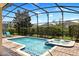 Screened-in pool and jacuzzi area with manicured landscaping and a secure enclosure at 9023 Shadow Mountain St, Davenport, FL 33896