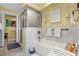 Bright bathroom featuring a bathtub, glass shower, and decorative tile at 111 E Monument Ave # 705, Kissimmee, FL 34741