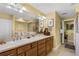 Bathroom with extended vanity, decorative fixtures, framed mirrors, and a walk-in glass enclosed shower at 111 E Monument Ave # 705, Kissimmee, FL 34741