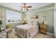 Bright bedroom with neutral walls, ceiling fan, shuttered window, and a plush bed with decorative pillows at 111 E Monument Ave # 705, Kissimmee, FL 34741