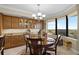 Dining room with dark wood table and chairs, decorative hutch, chandelier, and view from a large window at 111 E Monument Ave # 705, Kissimmee, FL 34741