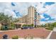 Elegant building exterior featuring brick-paved street, lush landscaping, and convenient street parking at 111 E Monument Ave # 705, Kissimmee, FL 34741