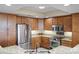 Modern kitchen with stainless steel appliances, granite countertops, and wooden cabinets at 111 E Monument Ave # 705, Kissimmee, FL 34741