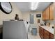 Well-lit laundry room with modern washer, dryer, storage cabinets, and practical folding counter space at 111 E Monument Ave # 705, Kissimmee, FL 34741