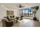Bright and airy living room with large windows, wicker furniture, and a green accent wall at 111 E Monument Ave # 705, Kissimmee, FL 34741