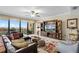 Cozy living room with leather sectional, entertainment center, ceiling fan, and sliding glass doors to a balcony at 111 E Monument Ave # 705, Kissimmee, FL 34741