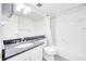 Clean bathroom featuring a granite countertop vanity, bathtub with shower, and white tile at 1100 Delaney Ave # F409, Orlando, FL 32806