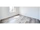 Inviting bedroom with light gray wood-look flooring, white walls, and a bright window at 1100 Delaney Ave # F409, Orlando, FL 32806