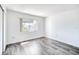 Bedroom with light gray wood-look flooring, white walls, and a large window for ample natural light at 1100 Delaney Ave # F409, Orlando, FL 32806