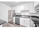 Well-lit kitchen with stainless steel appliances, white cabinets, dark countertops, and light gray wood-look floors at 1100 Delaney Ave # F409, Orlando, FL 32806