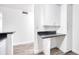 Kitchen featuring white cabinetry, dark countertops, light gray wood-look flooring, and plenty of storage at 1100 Delaney Ave # F409, Orlando, FL 32806