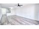 Spacious living room with light gray wood-look flooring, modern ceiling fan, and abundant natural light at 1100 Delaney Ave # F409, Orlando, FL 32806