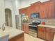 Well-lit kitchen featuring dark wood cabinetry, stainless steel appliances, and tile flooring at 13413 Zori Ln, Windermere, FL 34786
