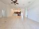 Large living room with tile floors and ceiling fan, leading to the kitchen with dark wood cabinets at 13413 Zori Ln, Windermere, FL 34786