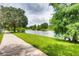 A scenic pond lined with lush greenery and a sidewalk offers a peaceful place for a stroll at 13413 Zori Ln, Windermere, FL 34786