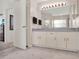 Neutral-toned bathroom with a double vanity, large mirror, and plenty of storage space at 14540 Pointe East Trl, Clermont, FL 34711