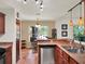 View of kitchen leading into the dining area; complete with stainless steel appliances and cherry wood cabinets at 14540 Pointe East Trl, Clermont, FL 34711