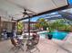 Relaxing covered lanai with a ceiling fan, outdoor dining set, and a view of the screened pool at 14540 Pointe East Trl, Clermont, FL 34711