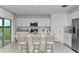 Bright kitchen featuring stainless steel appliances, white cabinets, a kitchen island with seating, and outdoor access at 146 Jones Fish Camp Rd, Edgewater, FL 32141