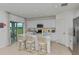 An open kitchen featuring white cabinets, a center island with seating, and stainless steel appliances plus a backyard view at 146 Jones Fish Camp Rd, Edgewater, FL 32141