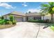 Charming single-story home featuring a spacious driveway, lush landscaping, and an attached two-car garage at 1489 Magellan Cir # 603, Orlando, FL 32818