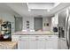 Bright kitchen island with white cabinets, dark hardware, and stainless steel refrigerator at 1489 Magellan Cir # 603, Orlando, FL 32818