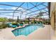 Sparkling screened-in pool with blue lounge chairs and a scenic backyard view at 1640 Prairie Oaks Dr, St Cloud, FL 34771