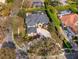Aerial view of a beautiful home with a circular driveway, a dark shingle roof and mature landscaping at 1704 Kersley Cir, Lake Mary, FL 32746