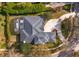 Aerial view of a home with a well-maintained roof, screened-in pool, driveway, and manicured landscaping at 1704 Kersley Cir, Lake Mary, FL 32746