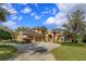 Stunning home featuring a stone archway entry, three-car garage, beautiful landscaping, and a circular driveway at 1704 Kersley Cir, Lake Mary, FL 32746