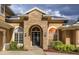 Elegant home entrance with stone archway, double doors, sidelights, and detailed landscaping at 1704 Kersley Cir, Lake Mary, FL 32746