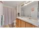 Bright bathroom with a double sink vanity, shower with curtain and neutral color palette at 1735 Pine Ridge Dr, Davenport, FL 33896
