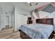 Bedroom featuring hardwood floors, light blue walls with a modern artistic accent wall, and white trim at 1735 Pine Ridge Dr, Davenport, FL 33896