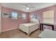 Bedroom featuring hardwood floors, pink walls, and white trim at 1735 Pine Ridge Dr, Davenport, FL 33896
