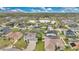 Community homes surround a pond in a sunny neighborhood filled with greenery and mature trees beneath a blue sky at 1827 Lindzlu St, Winter Garden, FL 34787