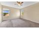 Bright bedroom featuring neutral walls, carpeted floors, a ceiling fan, and two windows with a view at 1827 Lindzlu St, Winter Garden, FL 34787