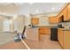 Kitchen features wooden cabinets, black appliances, tiled floors, and a center island, adjacent to living area at 1827 Lindzlu St, Winter Garden, FL 34787