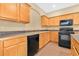 Kitchen featuring wooden cabinets, black appliances, dark countertops, and tiled floors, perfect for cooking at 1827 Lindzlu St, Winter Garden, FL 34787