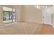 Bright living room featuring carpeted floors, neutral walls, sliding door access to a patio, and a white door at 1827 Lindzlu St, Winter Garden, FL 34787