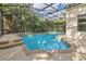 Inviting in-ground pool with a screened enclosure and stone trim provides a private oasis with a glimpse of the sky at 1827 Lindzlu St, Winter Garden, FL 34787